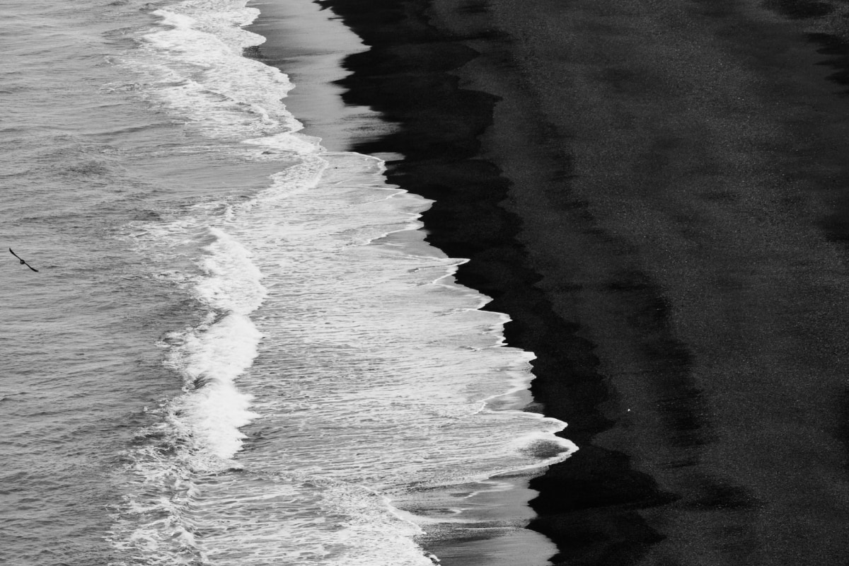 Ocean waves meeting the shore, black and white contrast